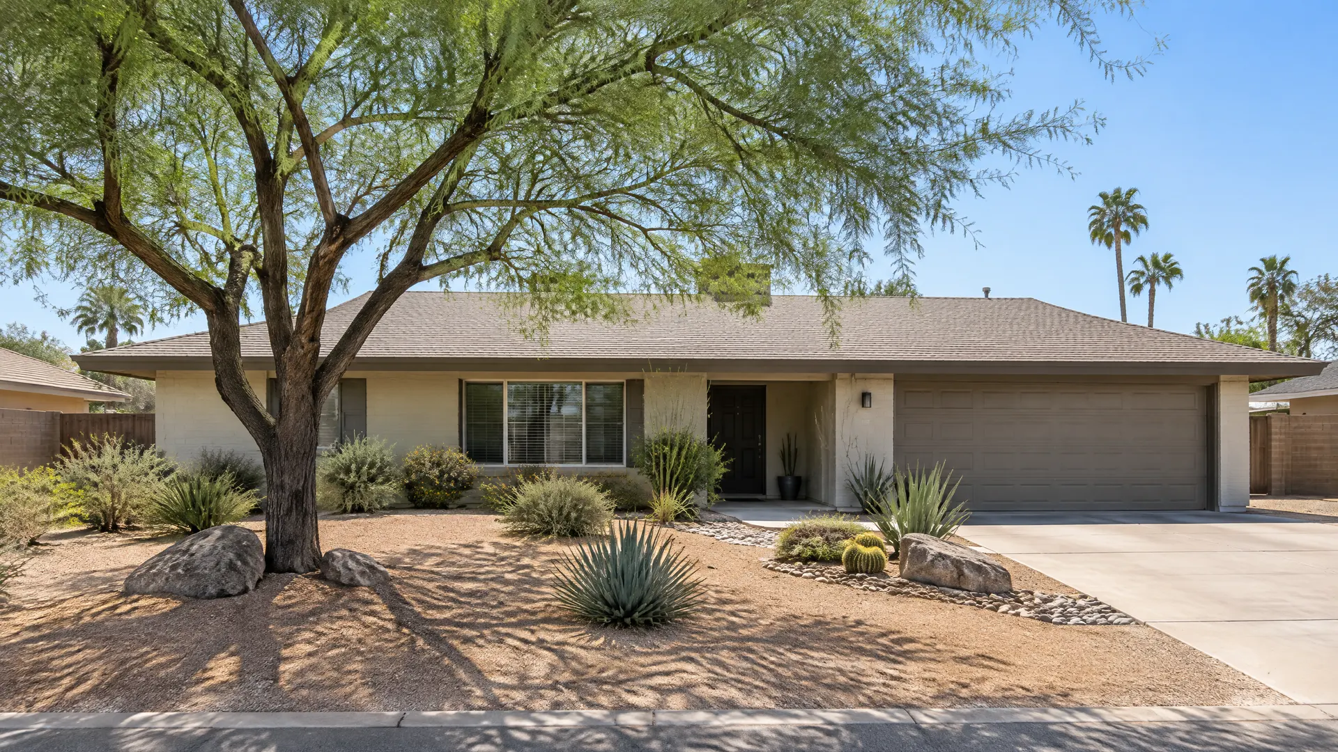 Single-story ranch home in central Tempe with a fresh desert front yard, a mesquite tree and decomposed granite
